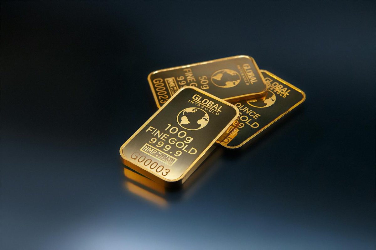Three premium FINE GOLD 999.9 bars on dark background