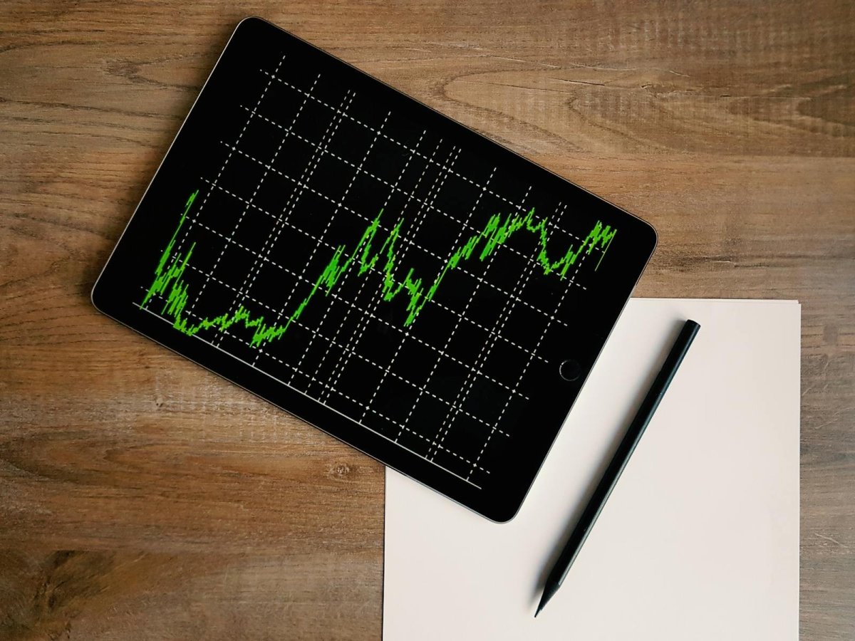 Tablet displaying green trading chart with weekly performance